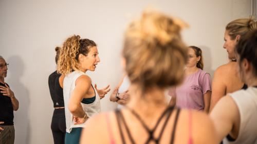 trainees in yoga training listening to and discussing with teacher