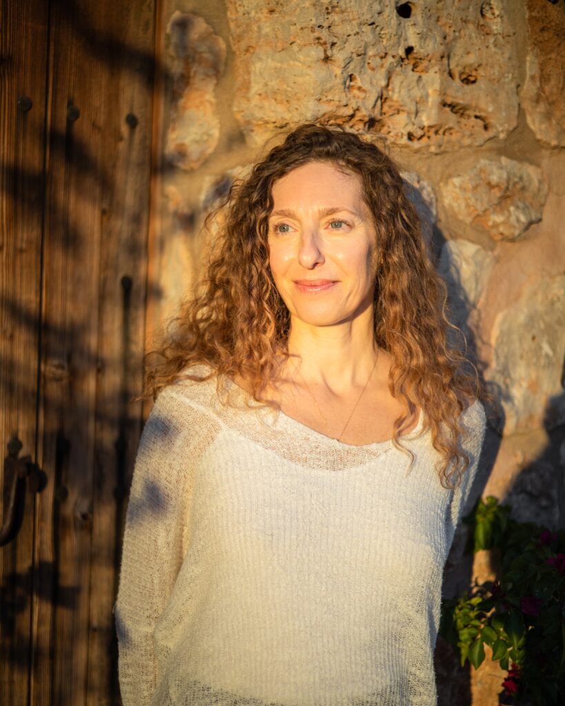 woman leaning onto a wall during sunset, reflecting