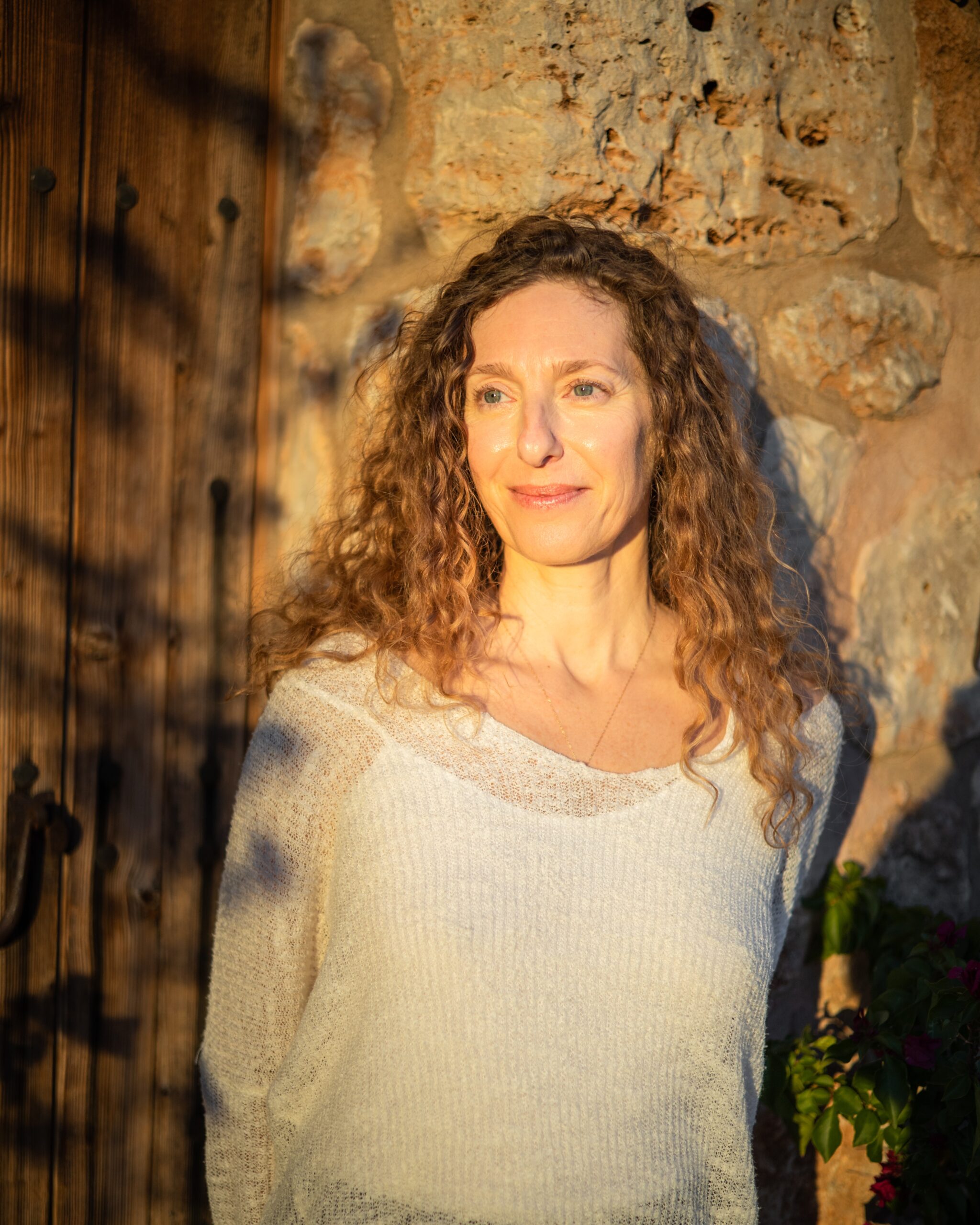 woman leaning onto a wall during sunset, reflecting